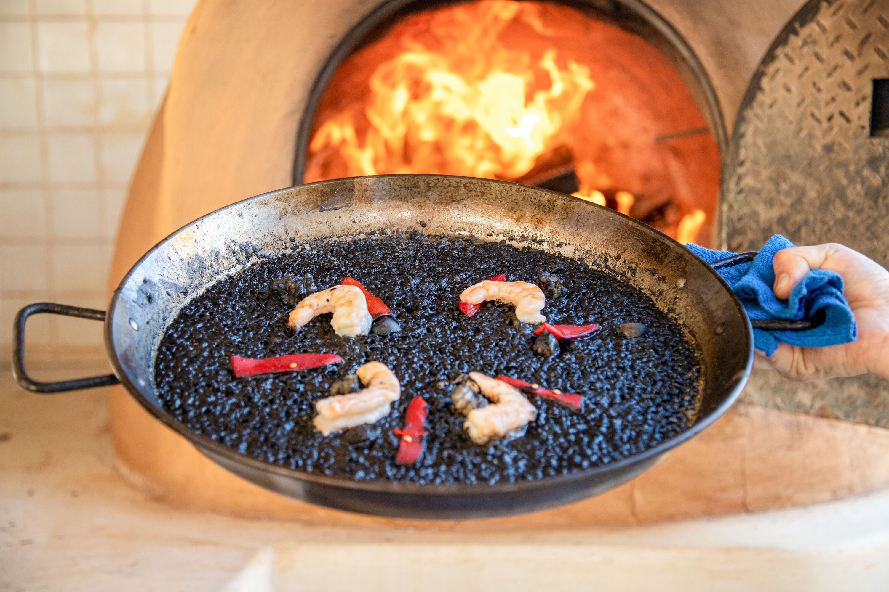 A pan with shrimp and red peppers on a grill.