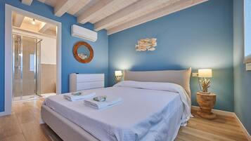 Una camera da letto con un letto, un comodino con lampada, un condizionatore d'aria a parete e un angolo doccia.