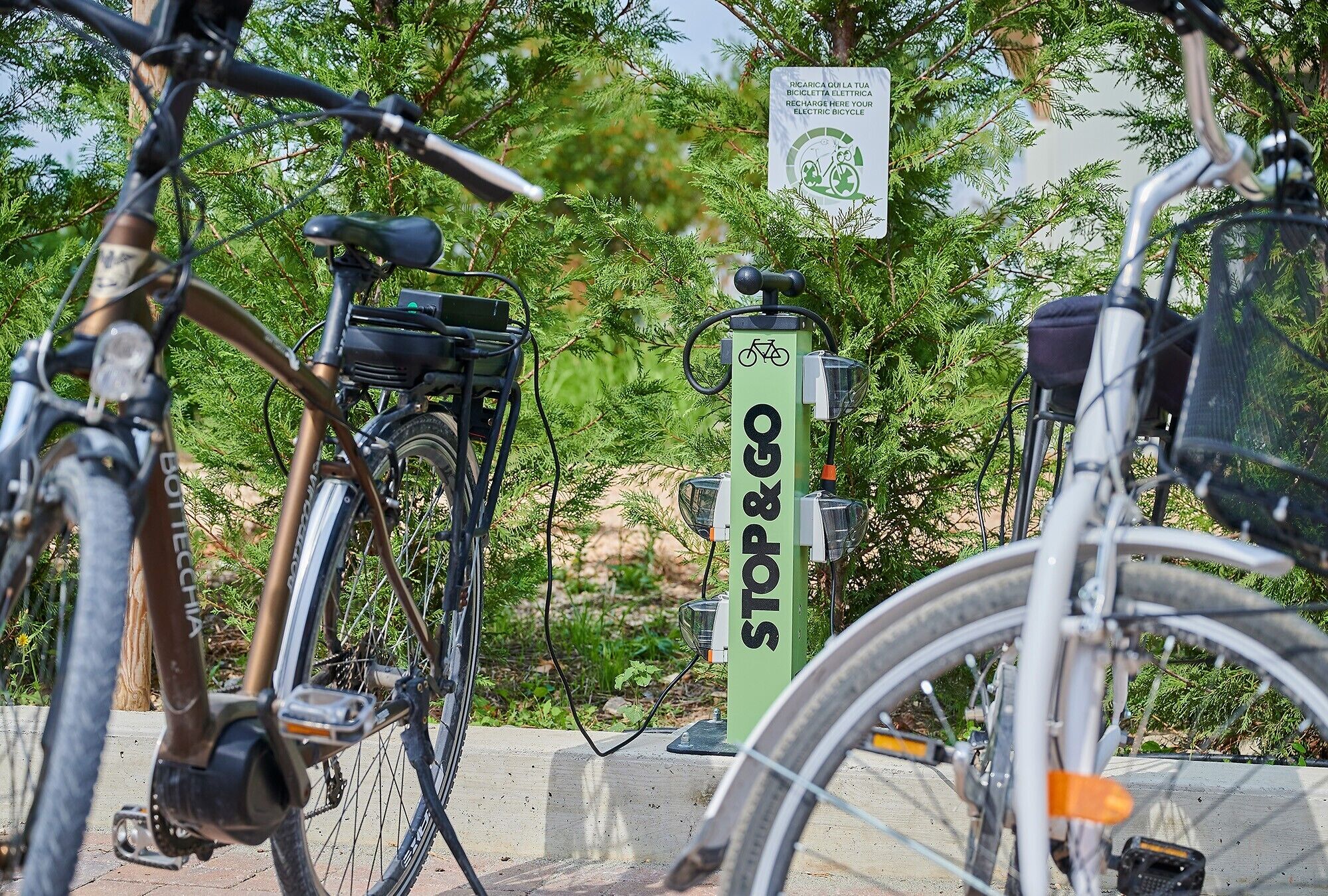 Des vélos sont garés près d’un panneau vert sur lequel on peut lire « ARRÊT ET DÉPART », ce qui laisse supposer qu’il s’agit d’une station de vélos en libre-service.