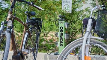 Des vélos sont garés près d’un panneau vert sur lequel on peut lire « ARRÊT ET DÉPART », ce qui laisse supposer qu’il s’agit d’une station de vélos en libre-service.