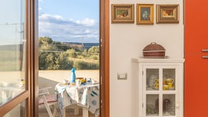 Une pièce avec une table mise pour le petit-déjeuner, un buffet rempli de vaisselle et des tableaux encadrés accrochés au mur.