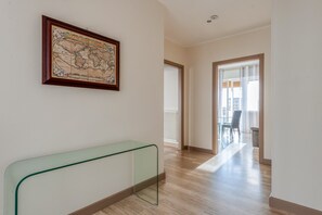 A hallway with a framed map, a glass bench, and a view into a dining area. - Apartment 'Victoria's Home' with Private Terrace, Wi-Fi and Air Conditioning (Lecce)