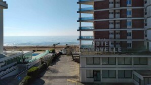 A hotel with multiple floors, a parking area, and a view of the beach. - Holiday apartment mit Balkon (Jesolo)