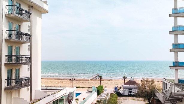 A view of a beach from a building with balconies overlooking the sea. - Holiday apartment mit Balkon (Jesolo)