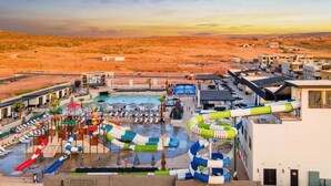 A resort with a pool area, water slides, and a desert landscape in the background. - Pecan Valley Resort|Private Pool w/Slide, Smart TV's, & Pickleball Court (Hurricane)