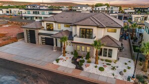 A modern two-story house with a garage, a driveway, and a landscaped front yard with palm trees and decorative rocks. - Pecan Valley Resort|Private Pool w/Slide, Smart TV's, & Pickleball Court (Hurricane)