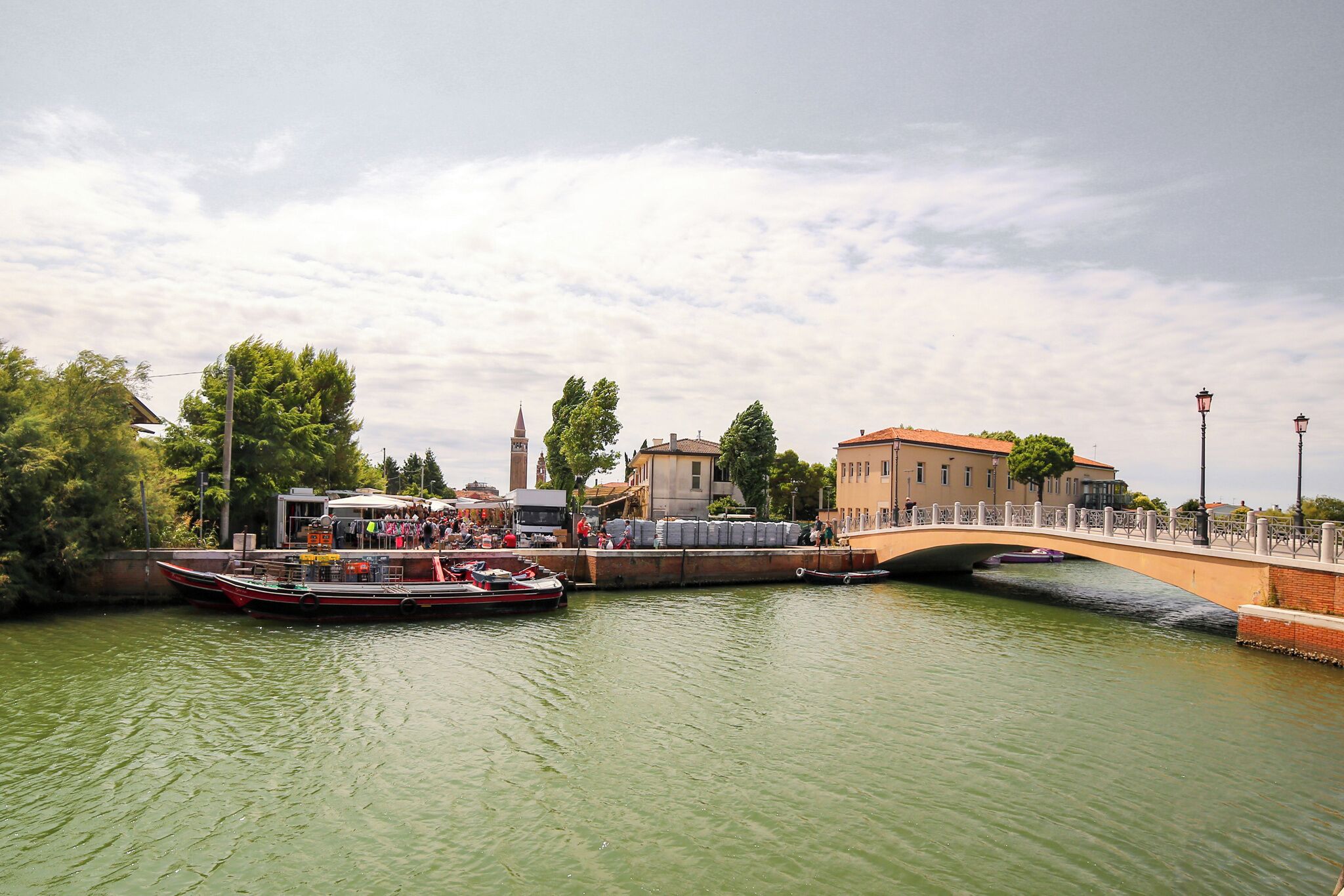 A river with a bridge, boats, and buildings along the banks.