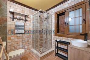 Une salle de bain équipée d’une douche, de toilettes, d’un lavabo et d’une fenêtre avec un cadre en bois.