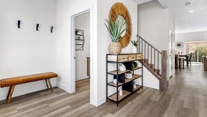 A modern interior with a wooden bench, a wall-mounted shelf with decorative items, and a staircase leading to another room. - The Vues 6|Resort Pool, Ping Pong Table, Private Blacony (St. George)