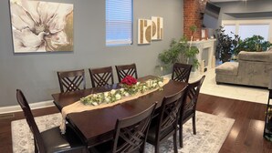 A dining area with a long table, dark wooden chairs, and a decorative centerpiece. - Luxury Fully Furnished Spacious 3 BDR 3 Full BTH Columbus Home with Amenities! (Columbus)