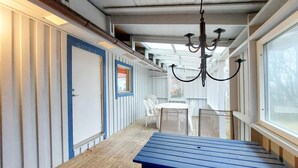 A covered outdoor area with a blue bench, white chairs, and a chandelier. - 2 bedroom lovely home in Klippan (Klippan)