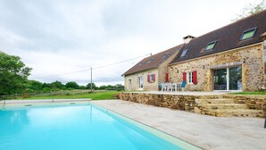 A stone building with a swimming pool, outdoor seating, and a view of the surrounding greenery. - Gîte De L’Egal – Cadouin, Sleeps 10, Air-Conditioned, Private Pool, Périgord Charm (Le Buisson-de-Cadouin)