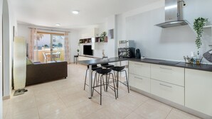 A modern kitchen with a dining area, a large window, and a built-in stove.