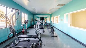 A gym with various exercise equipment, including treadmills, stationary bikes, and weight machines.