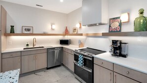 Una cocina moderna con electrodomésticos de acero inoxidable, microondas, cafetera y un cartel que dice 'Kitchen Disco'.