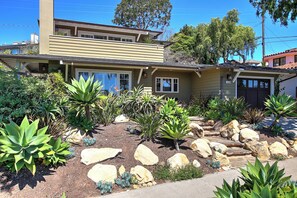 Stroll up to the front door of this two-story residence, surrounded by a lush, desert-inspired garden.