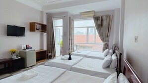 A hotel room with two beds, a TV, a desk, and a window with curtains. - Amy Hotel Hue (Hue)