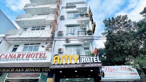 A multi-story hotel with balconies and a sign for "Canary Hotel". - Amy Hotel Hue (Hue)