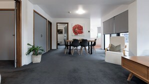 Una habitación moderna con comedor, un ventanal grande y una planta.