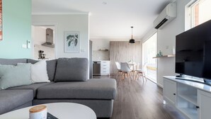 A modern living room with a grey sofa, a white coffee table, and a flat-screen TV on a white cabinet. - Cosy & Sweet: Near the City, WiFi & Parking (Launceston City)