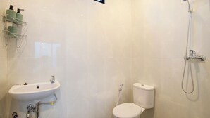 A bathroom with a sink, toilet, and shower.