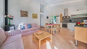 A modern living room with a sofa, a wooden coffee table, and a dining area with a table and chairs. - Villa La Sort 140 - By Dream Villas Pollensa (Pollensa)