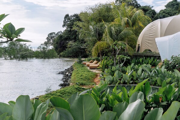 Vista al río con una carpa y sillones de descanso.