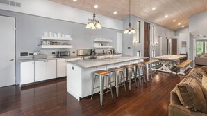 Une cuisine moderne dotée d’un îlot central, de tabourets de bar et d’une table à manger.