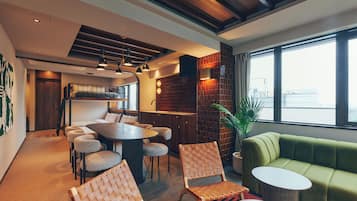A modern interior with a dining area, a bunk bed, and a green sofa.