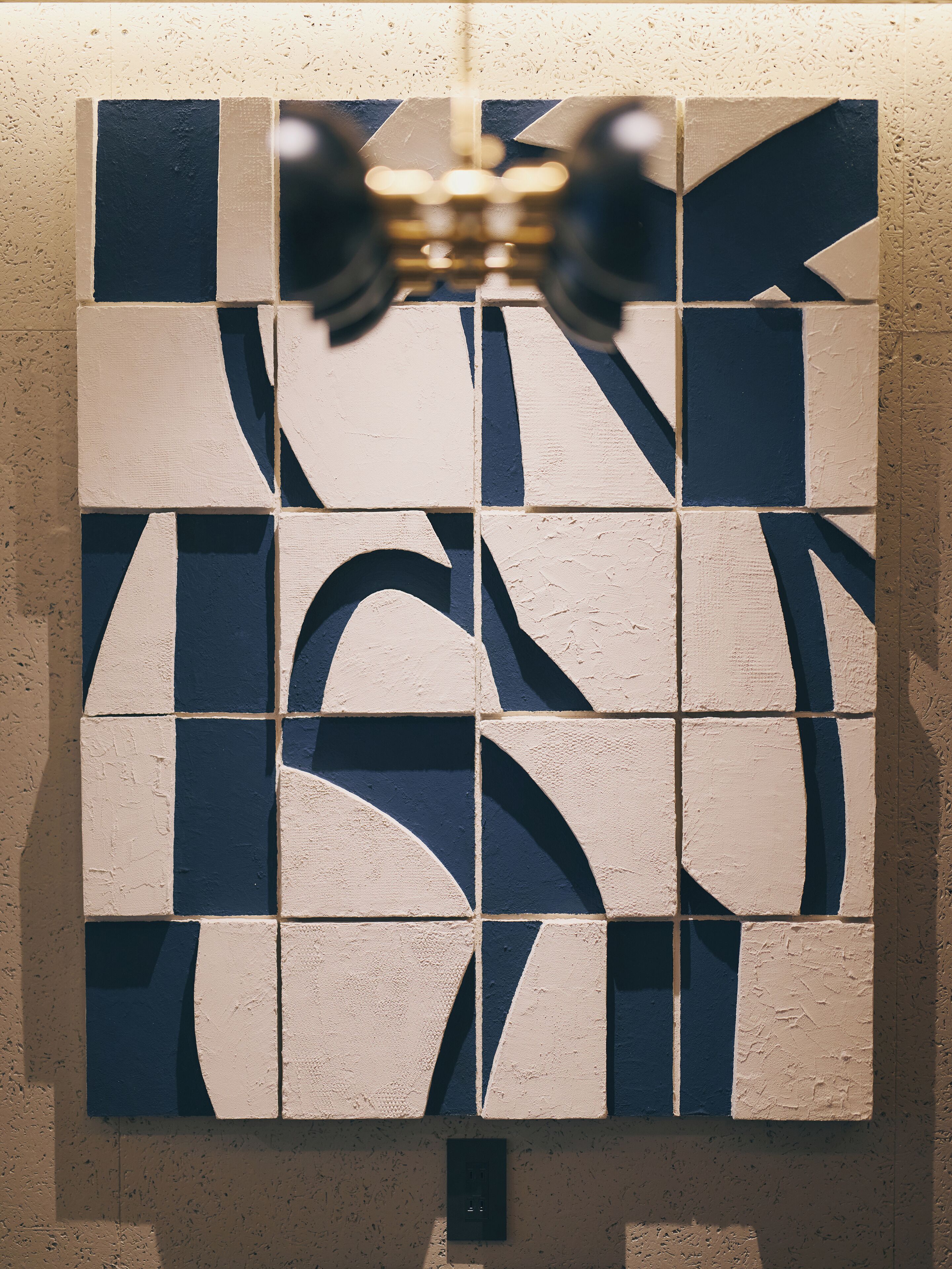 A wall with a geometric pattern of tiles in two colors.
