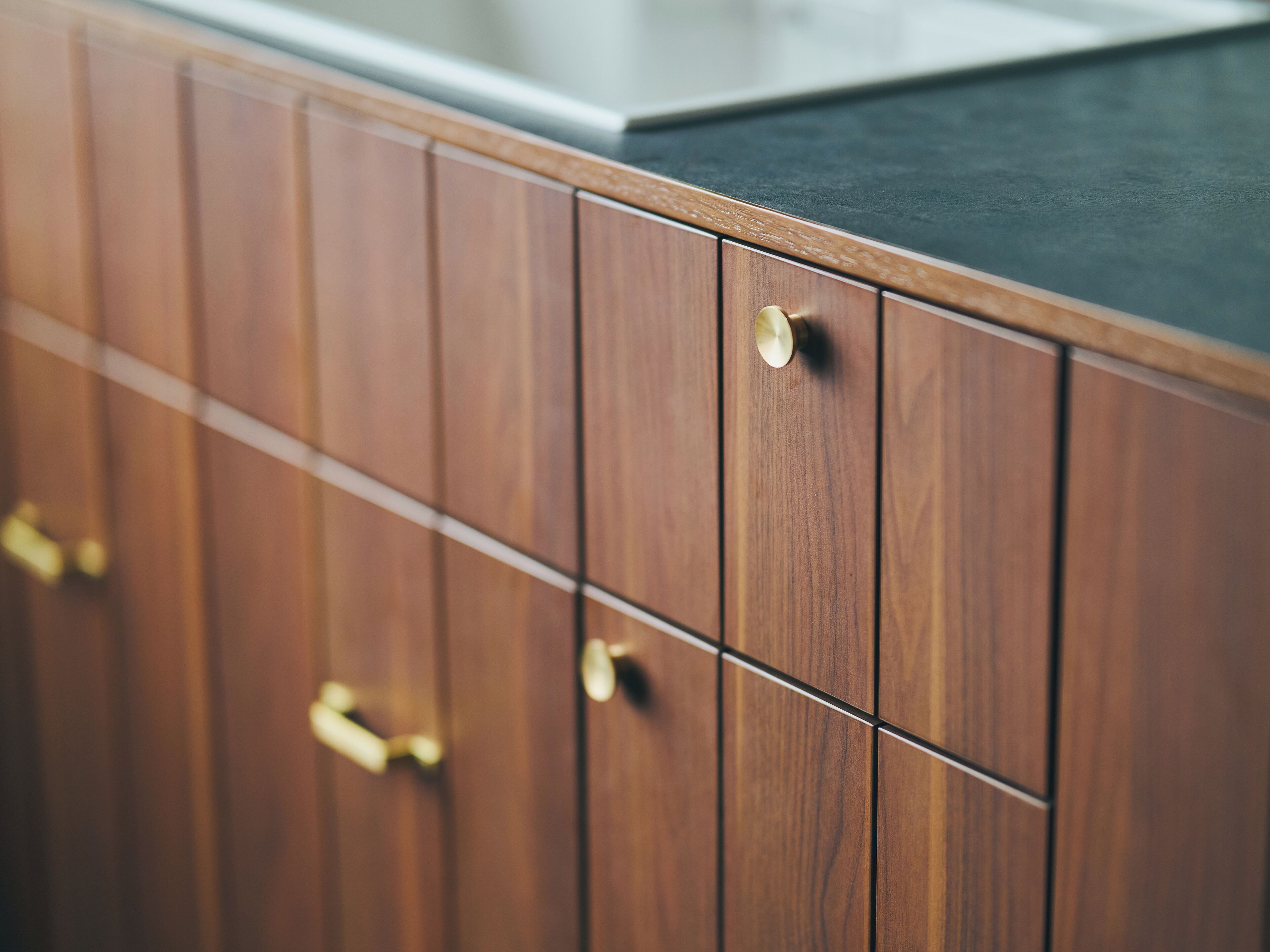 A wooden cabinet with a black countertop.