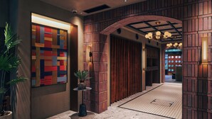 A modern interior with a wooden panel wall, a geometric art piece, and a potted plant. - STITCH HOTEL KYOTO (Kyoto)