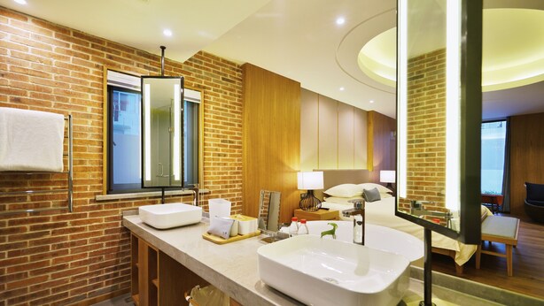 Un baño moderno con un lavamanos grande, un espejo y una ventana.