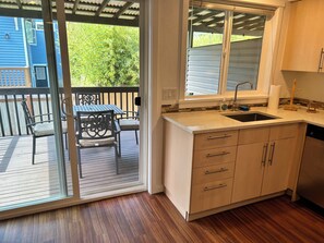 A kitchen with a sink, countertop, and wooden cabinets. - Charming 2-bedroom condo with WiFi in Bellingham (Bellingham)