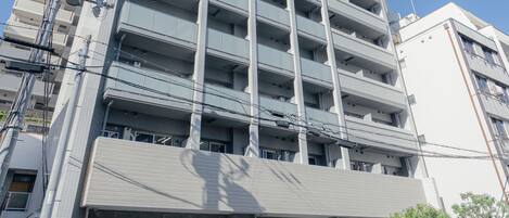 A multi-story parking garage with a modern design, featuring a series of balconies and a covered entrance.