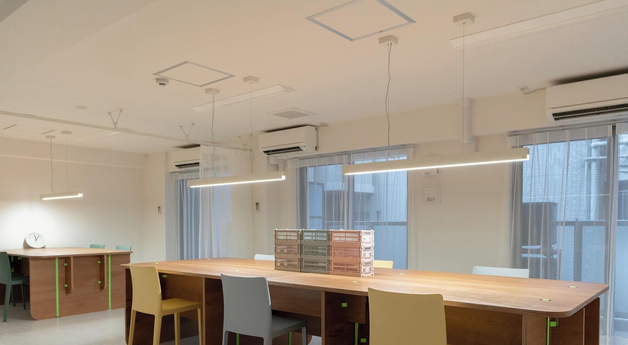 Una sala de conferències amb una taula llarga, cadires i un rellotge a la paret.