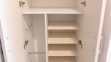 A white closet with multiple shelves and hanging rods.