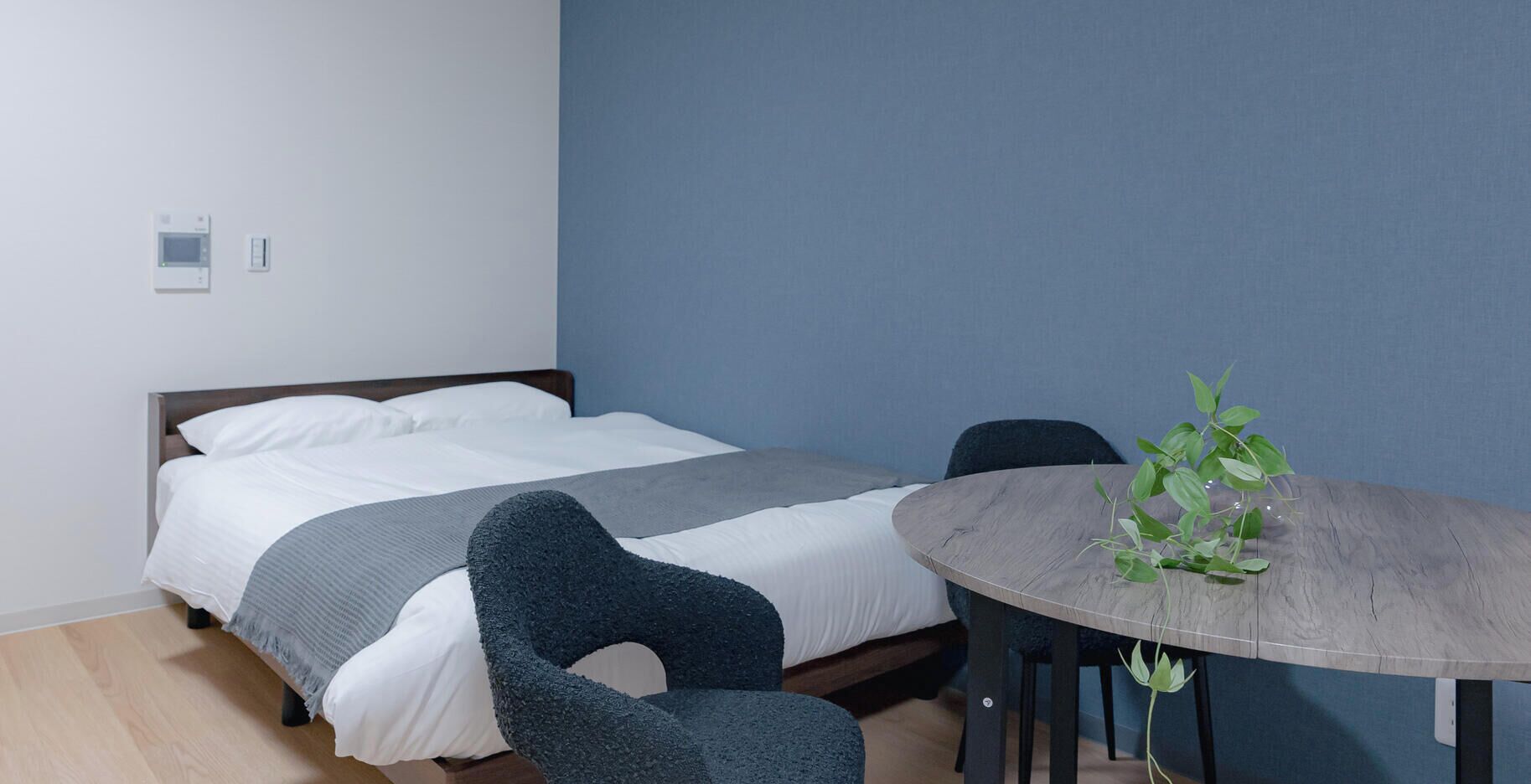 Een kamer met een bed, een ronde tafel en een stoel.