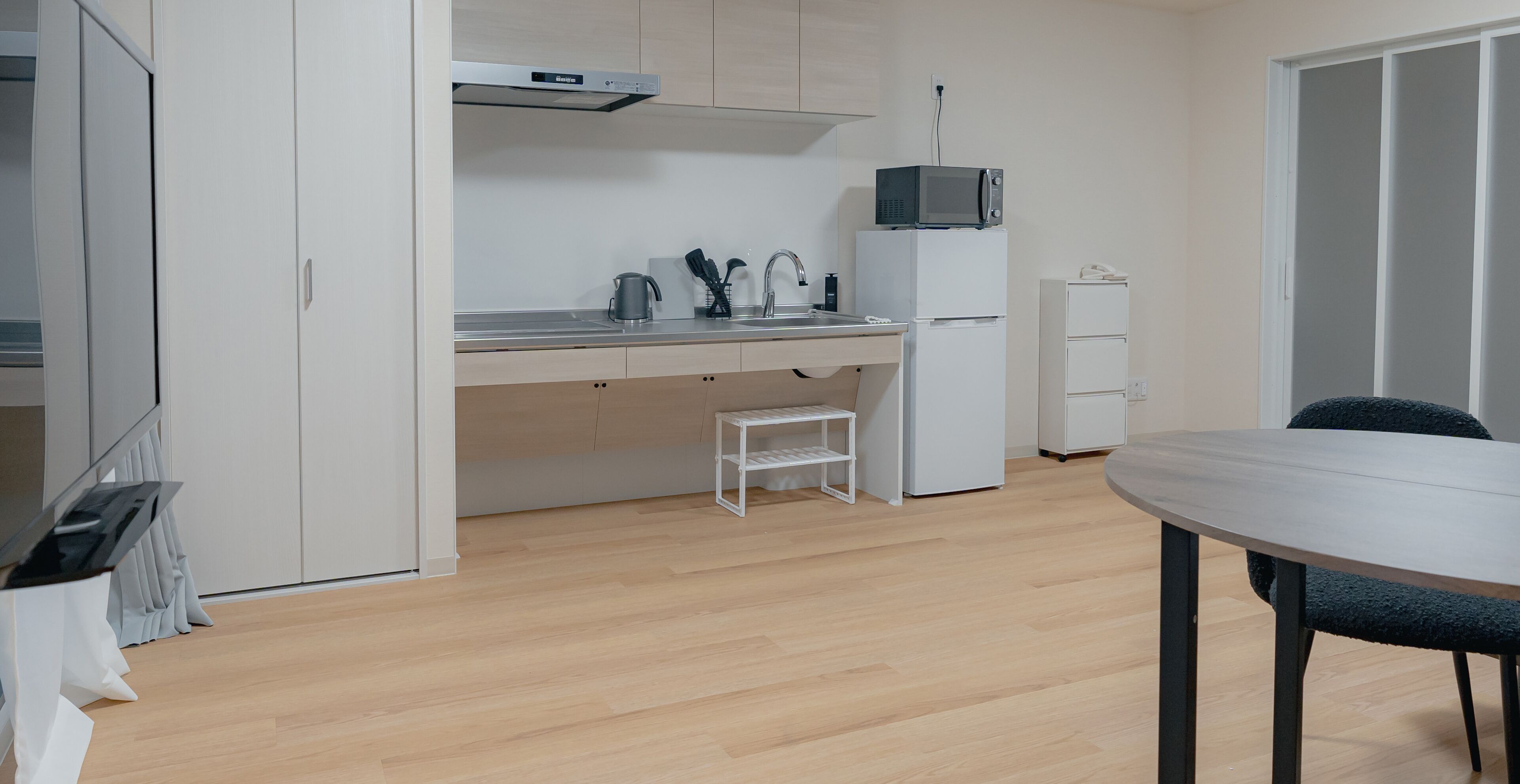 A compact kitchen with a microwave, sink, and refrigerator.