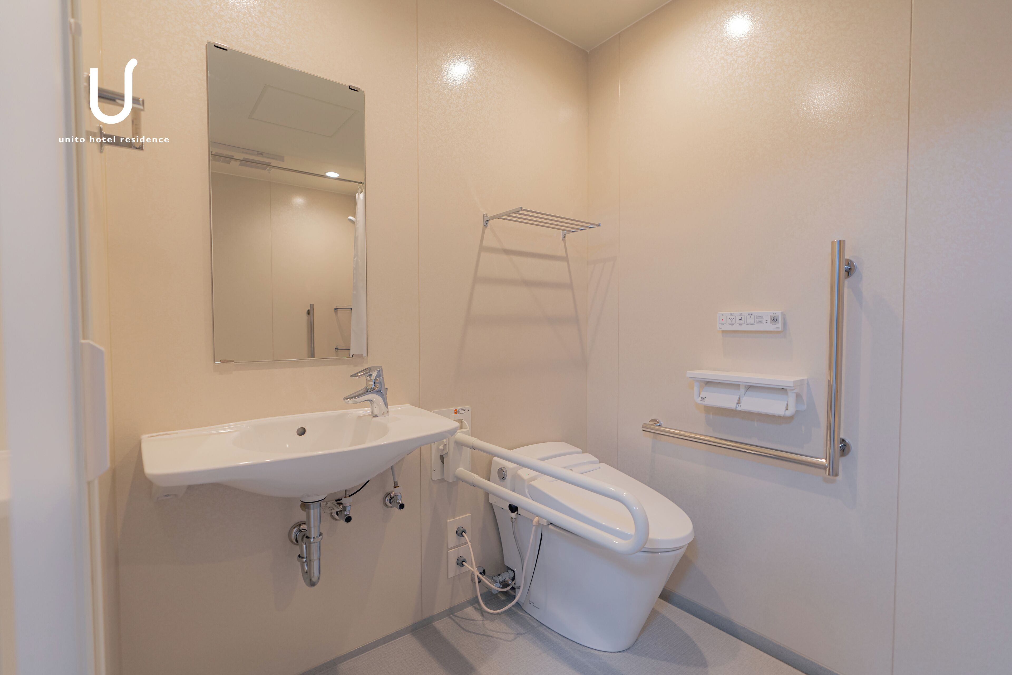 Een moderne badkamer met een witte wastafel, spiegel en toilet.