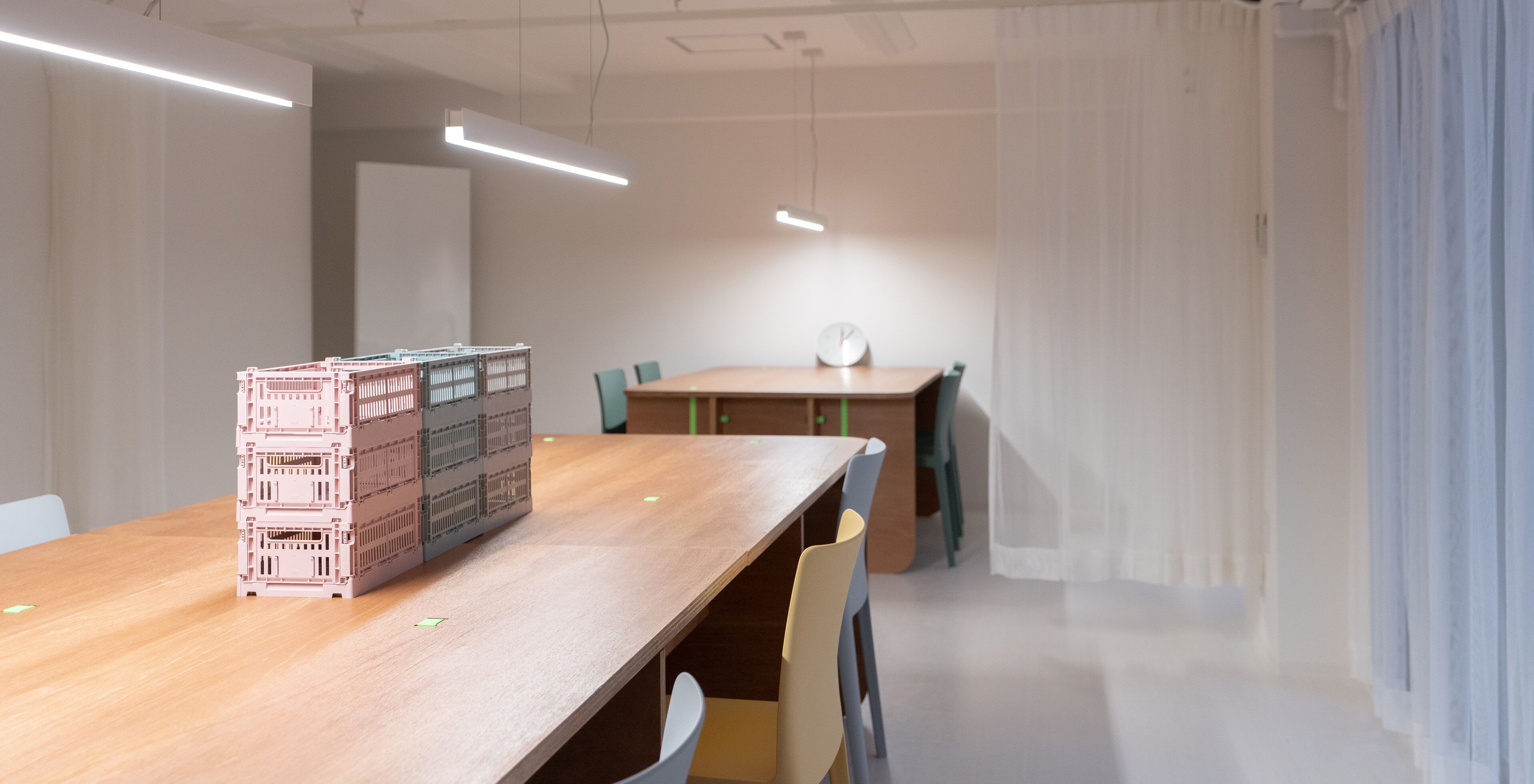 Una sala de conferencias con una mesa de madera, sillas, un reloj y una maqueta.