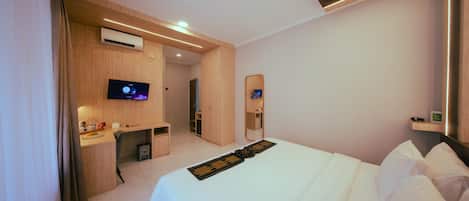Una habitación de hotel moderna con cama, escritorio, televisor y baño.
