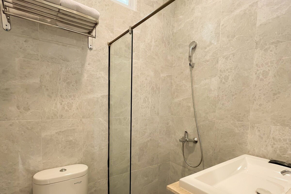Une salle de bain avec une douche à parois de verre, des toilettes et un lavabo.