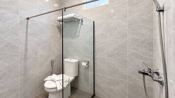 Une salle de bain moderne avec une douche à parois de verre, des toilettes et un porte-serviettes.