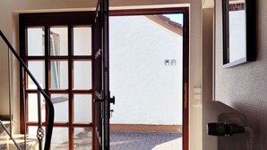 A staircase leading to a door with a view of a paved area outside.