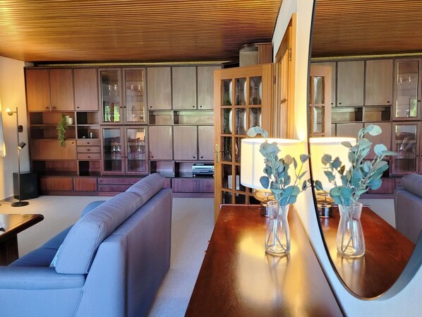 Una sala de estar moderna con techo de madera, armarios empotrados, un sofá y una mesa de centro.