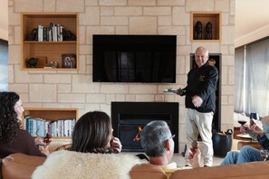 A living room with a fireplace, bookshelves, and a flat-screen TV.