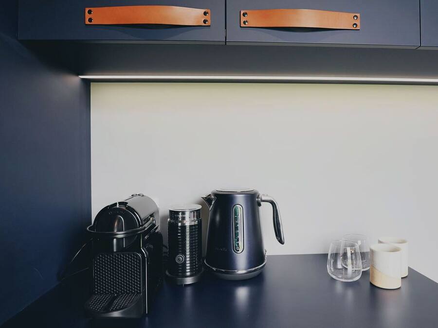 Eine Küchenarbeitsplatte mit Kaffeemaschine, Wasserkocher und Mixer.