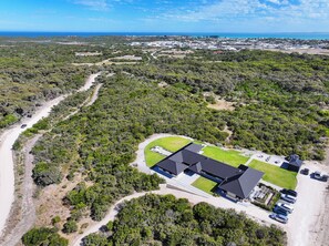 An aerial view of a property with a large building, parking area, and surrounding greenery. - Stony Rise Lodge (Robe)