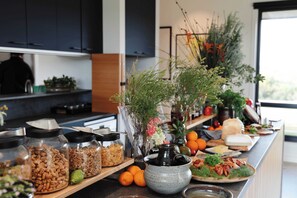 A kitchen counter with various food items, including jars of granola and fresh produce.